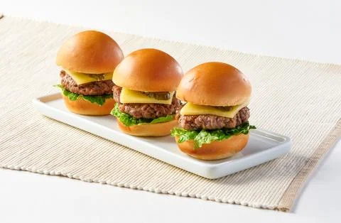 US Angus Beef Sliders or Mini Cheeseburgers on White Platter, each with a j.. Foto stock