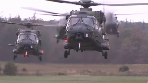 US Apache helicopters land on field Stock Footage 120948643