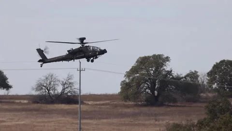 U.S. Army AH-64 Apache flying at low altitude over brushland Vídeos de archivo 301062920