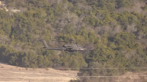U.S. Army AH-64 Apache flying through hilly terrain Vídeos de archivo 301062921