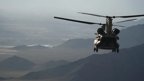 U.S. Army CH-47 Chinook in flight above mountains of Afghanistan Stock Footage 87318848