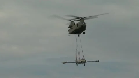 U.S. Army CH-47 Chinook transporting F-80 'Shooting Star' aircraft by sling load Stock Footage 211806542