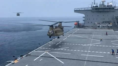 U.S. Army CH-47 Chinook landing aboard USS Miguel Keith with CH-47 approaching Stock Footage 239325352