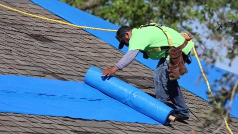 U.S. Army engineer unrolling sheeting during blue roof installation Stock Footage 162308282