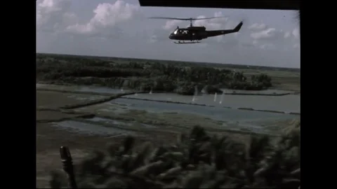 US Army Helicopters In Flight Over Rice Paddies Shooting   In Vietnam Stock Footage 97607359