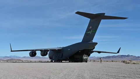 U.S. Army HIMARS exiting from U.S. Air Force C-17 Globemaster III in desert Stock Footage 294679948