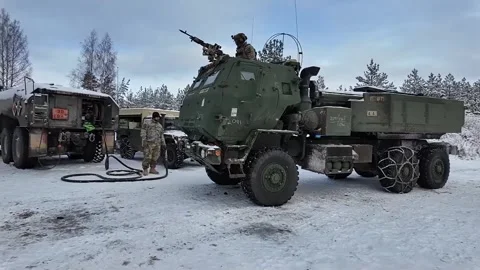 U.S. Army HIMARS pulling into snow covered compound for refueling Stock Footage 301195452