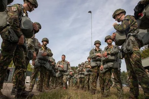 A U.S. Army Jumpmaster walks through a formation of Dutch Paratrooprs wait... Stock Photos