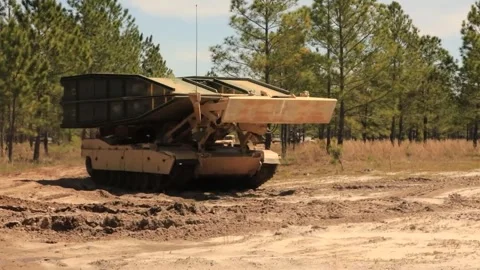 U.S. Army M1074 Joint Assault Bridge travelling on rutted sandy road Stock Footage 271338329