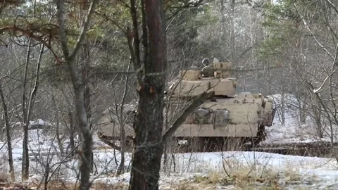 U.S. Army M1A2 Abrams tank travelling through snow covered forest Vidéo 227160779