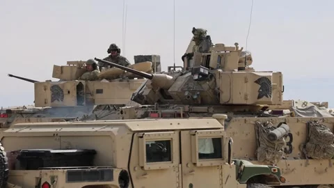 U.S. Army M2A3 Bradley Fighting Vehicle maneuvering past Oshkosh JLTV Stock Footage 301062800