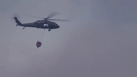 US Army Medevac preparing to drop water on a forest fire Stock Footage 94236013