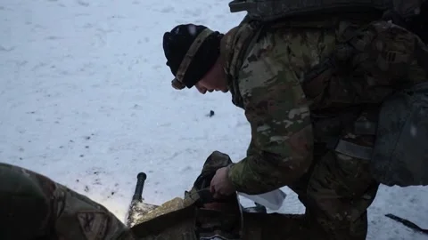 U.S. Army medic fitting oxygen mask to casualty lying on stretcher Stock Footage 257770333