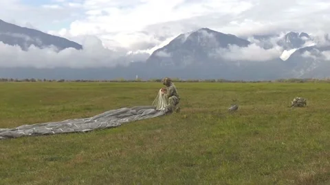 U.S. Army paratrooper packing parachute into bag Stock Footage 221554005