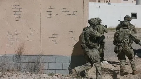 U.S. Army paratroopers advancing between buildings at urban terrain village Stock Footage 268824088
