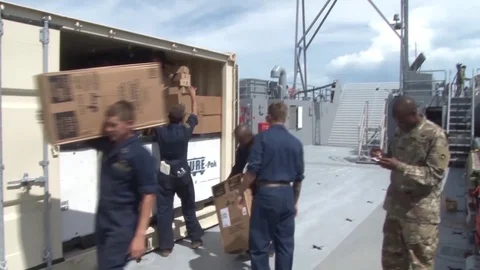 U.S. Army seamen unloading boxes from steel container aboard LCU Stock Footage 93826887