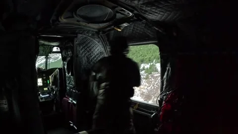 U.S. Army soldier looking out from side window of CH-47 Chinook during flight Stock Footage 295350146