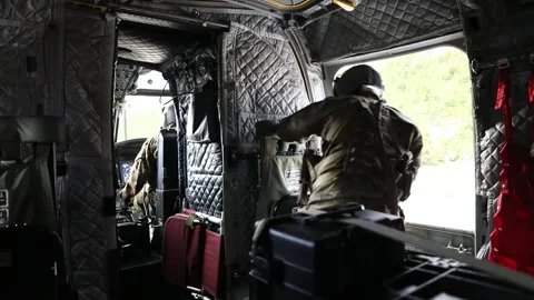 U.S. Army soldier looking out from side door of CH-47 Chinook during landing Stock Footage 295350169