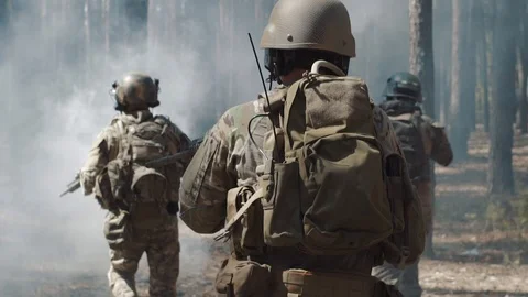 US Army soldiers run through the smoggy forest during battle Stock Footage