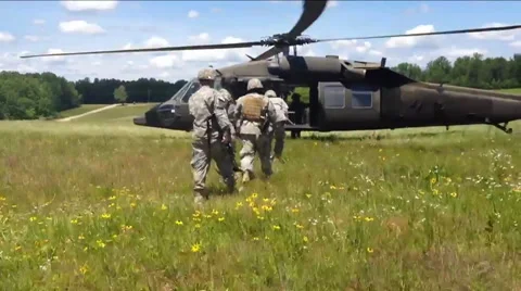 U.S. army troops load into a Blackhawk helicopters and fly off on a mission. Видео 67636878