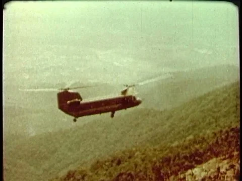 U.S. assault forces deploy from two bladed helicopters in 1969 in Vietnam, onƒ Stock Footage 75770235