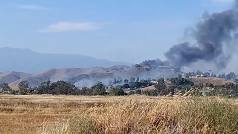 US: Brush Fire Erupts in Jurupa Valley, California, Prompting Evacuations... Stock Footage 332825169