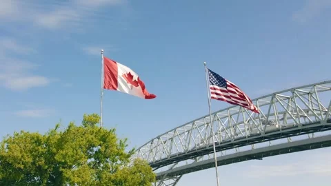 US &amp; Canada Flags closeup with  Blue Water Bridge Stock Footage 311999965