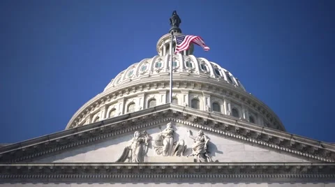 US Capitol Building Dome extreme low angle with Flag Flowing, clear blue sky Stock Footage 46943382