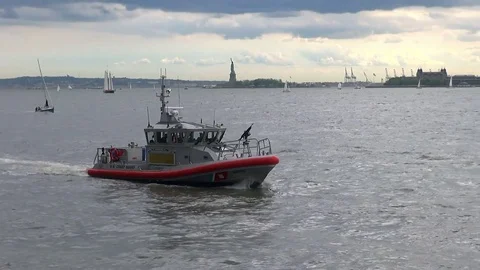 U.S. Coast Guard Boat with Machine Gun Patrols NY Harbor Near Statue of Liberty Stock Footage 76949716