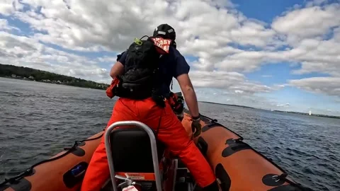 U.S. Coast Guard crew member piloting speedboat during pursuit training  Stock Footage 213580735