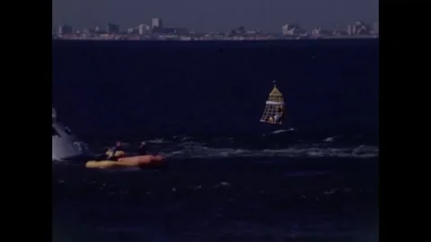 U.S Coast Guard helicopter hoisting astronaut from life raft near command module Stock Footage 271517643