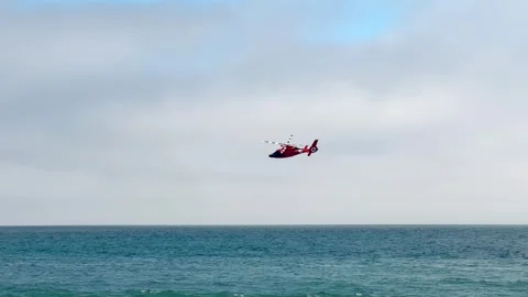 US Coast Guard helicopter in a training or search mission over the Pacific Stock Footage 248410564
