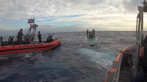 U.S. Coast Guard intercept and board semi-submersible suspect smuggling vessel Video stock 263720875