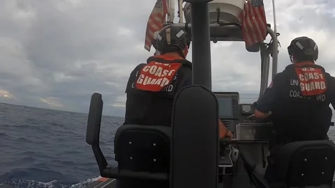 U.S. Coast Guard making his way to the front of rigid inflatable patrol boat Video stock 263721104