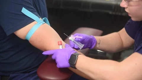 U.S. Coast Guard medic inserting syringe into patients arm during blood draw Stock-Footage 211806426
