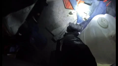 U.S. Coast Guard shining a torch on illegal immigrants aboard intercepted boat Stock Footage 300439879