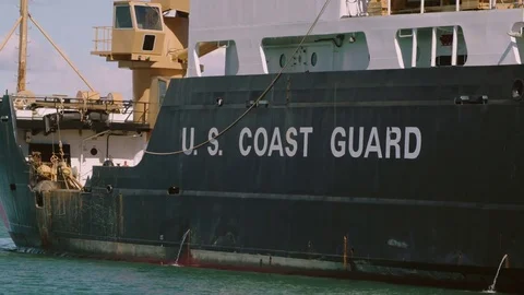 US Coast Guard Ship is parked at Dock in Safe Harbor with Mountains Stock Footage 83142734