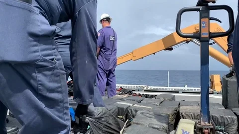 U.S. Coast Guard stack bales of seized cocaine aboard Cutter Bertholf Stock Footage 120074188