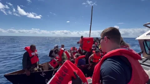 U.S. Coast Guard throwing life jackets to migrants in boat Stock Footage 234407433