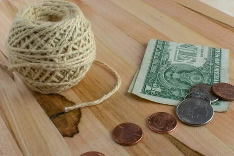 US Currency and a Ball of String on Wooden Table Stock Photos