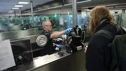 U.S. Customs and Border Protection officer taking photograph of passengers' eyes Stock Footage 295113287