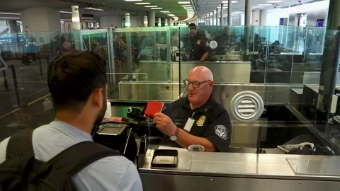 U.S. Customs Border Protection officer processing passenger at passport control Stock Footage 295113385