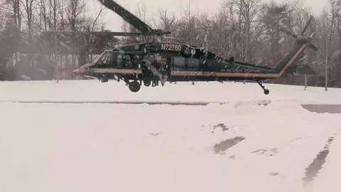U.S. Customs Border Protection UH-60 Black Hawk helicopter takes off in snow Stock Footage 299566527