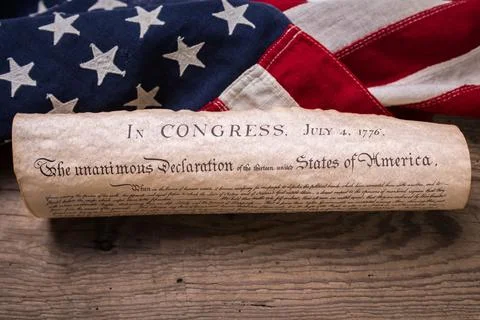 US Declaration of Independence rolled in a scroll on a vintage American flag Stock Photos