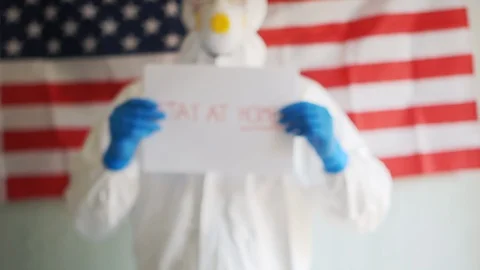 US doctors urge people to isolate themselves. Lettering on paper stay at home Stock Footage 128777628