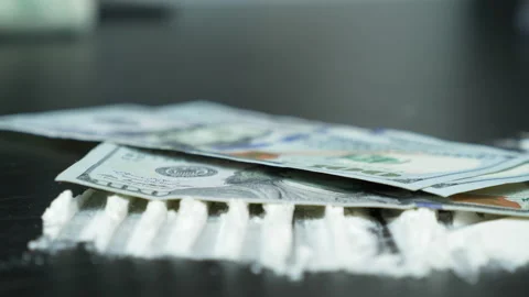 US dollar banknotes at 100 are pouring on table with cocaine or white powder Stock Footage 141700461