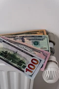 US dollar banknotes on central heating radiator with thermostat valve Stock-Fotos