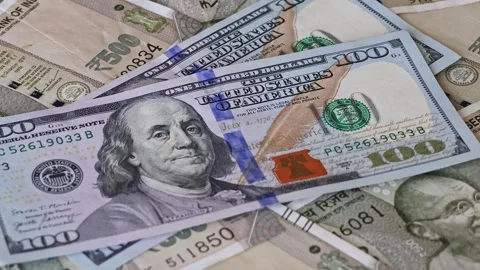 US dollar banknotes falling on Indian rupee notes. Real time footage. Stock Footage 332840981