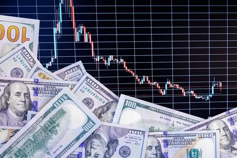 US dollar banknotes over digital screen with exchange chart, depreciation and Stock Photos