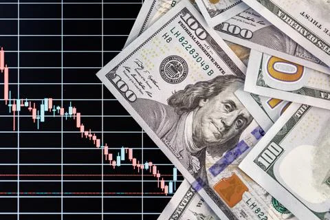 US dollar banknotes over digital screen with exchange chart, depreciation and Stock Photos